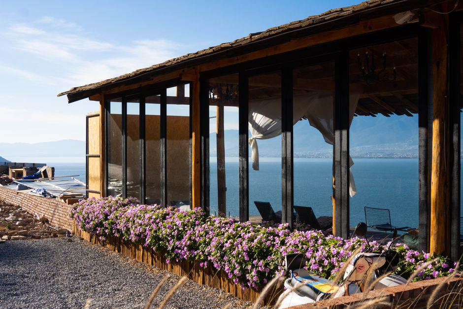 Scenic view of a lakeside house with flowers in Dali, China.