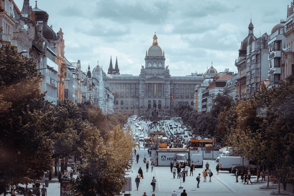 A bustling day in Prague's iconic Wenceslas Square with people, architecture, and vibrant city life.