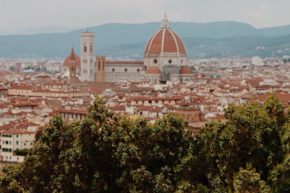 View of Florence Cathedral with the bustling cityscape of Florence, Italy in the background.
