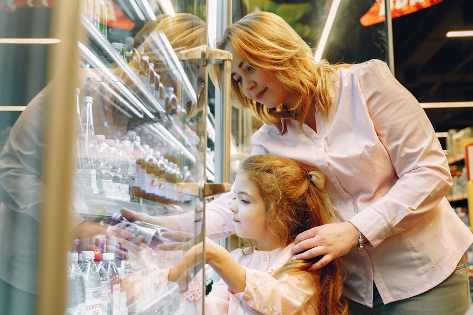 A mother and daughter selecting drinks from a supermarket refrigerator.